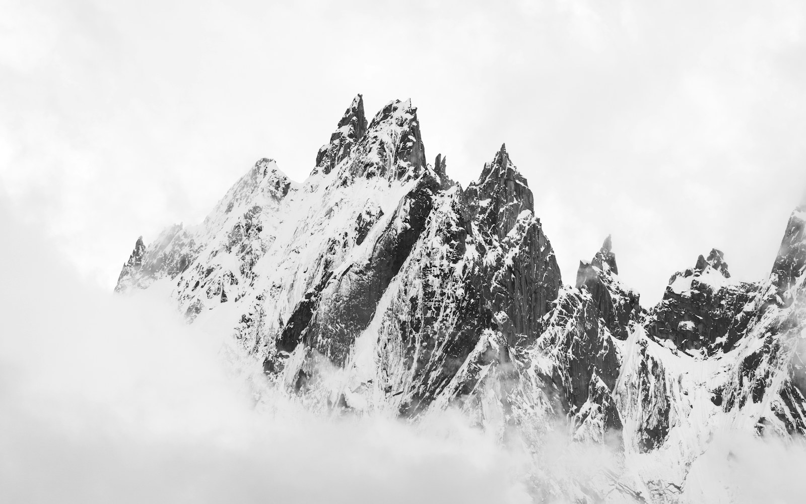 Black and white mountain photograph with sharply defined snowy peaks